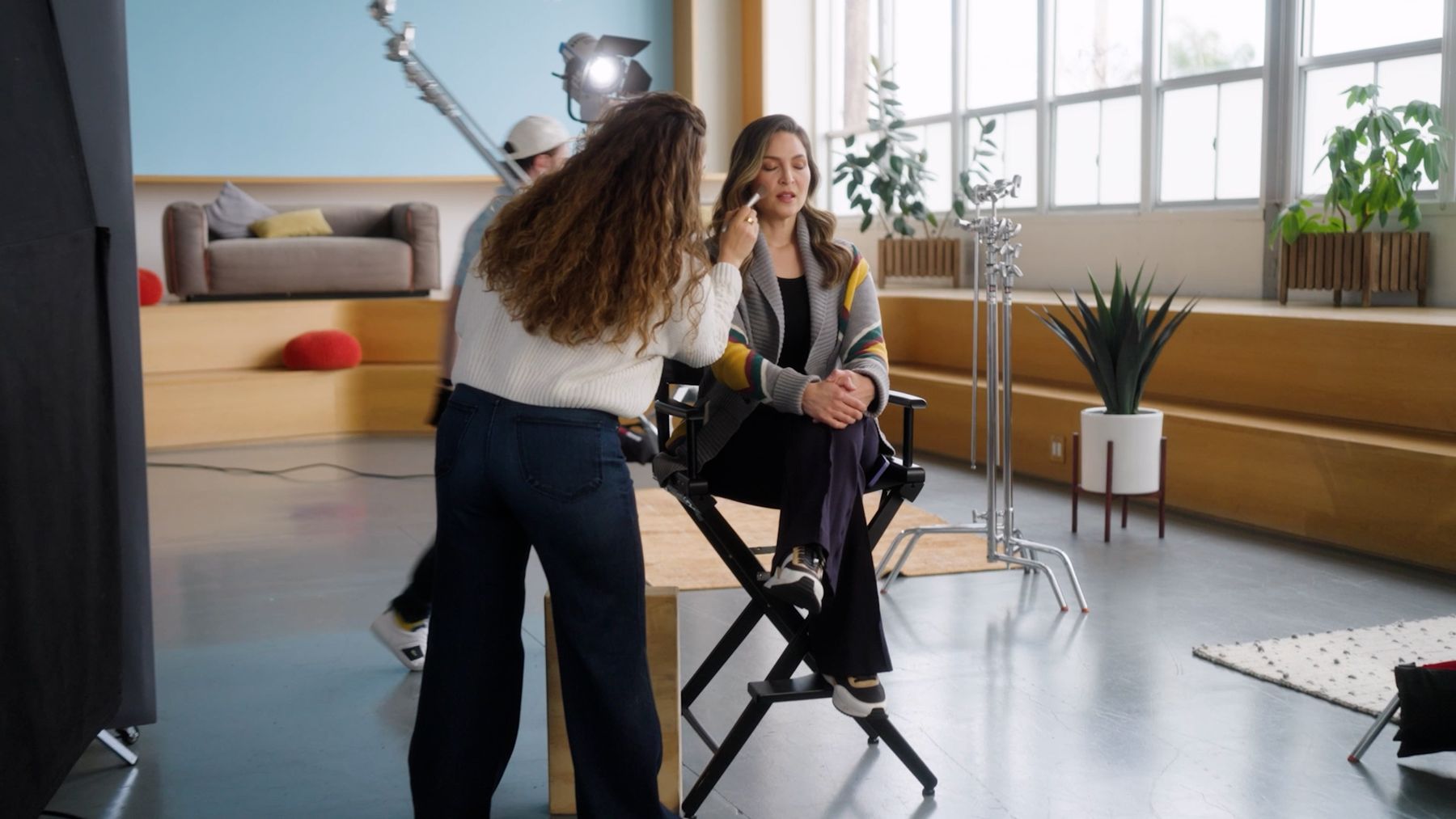 Behind the scenes: talent in a director's chair on a loft set